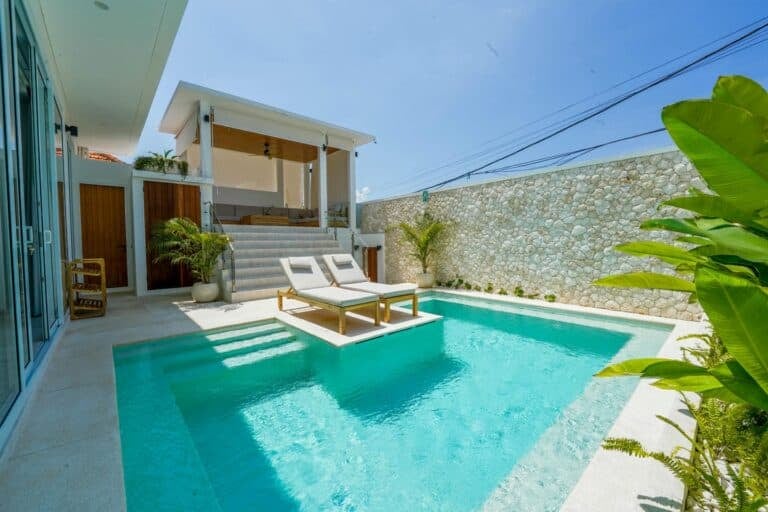 Luxurious poolside with loungers and modern patio.