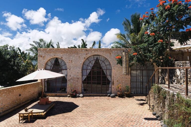 Stone building with arched windows and outdoor seating.