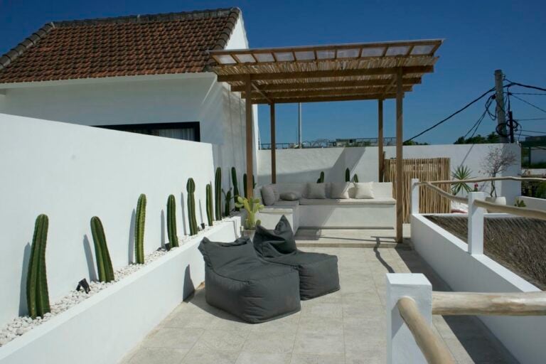 Rooftop patio with cacti and seating area.