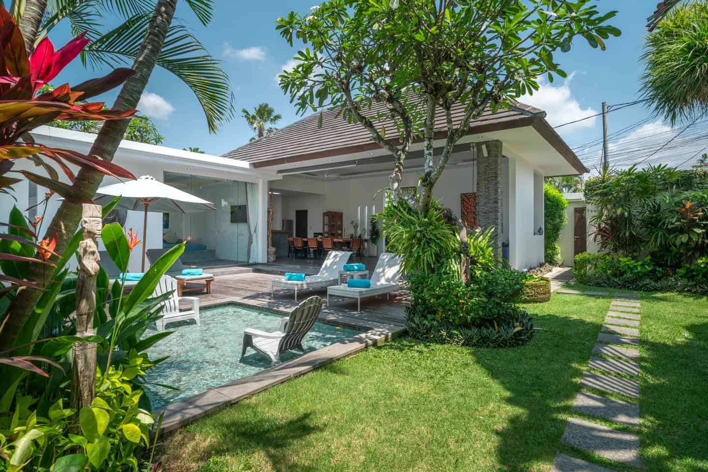 Luxurious villa garden with pool and patio.