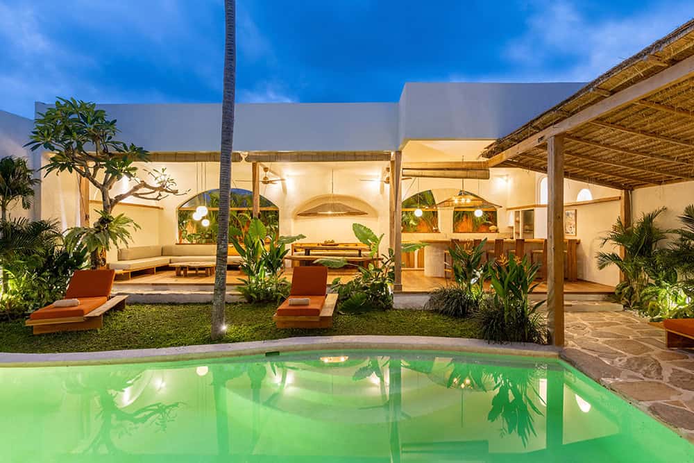 Modern open-air living space with pool at dusk.