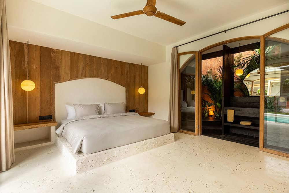 Cozy bedroom with wooden decor and pool view.