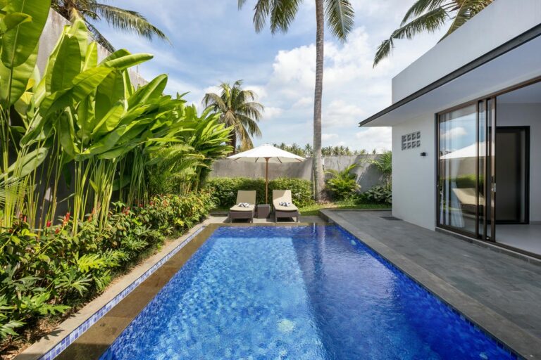 Modern villa with pool and tropical plants.
