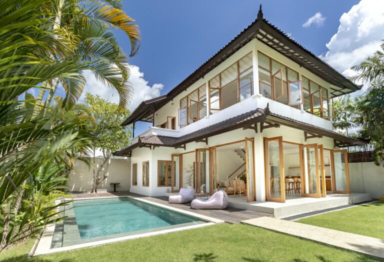 Modern tropical villa with pool and lush garden.