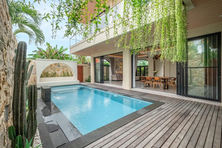 Modern patio with pool and outdoor dining area.