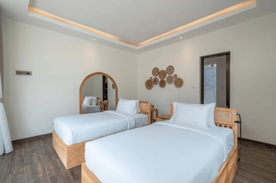 Modern bedroom with twin beds and wall decor.