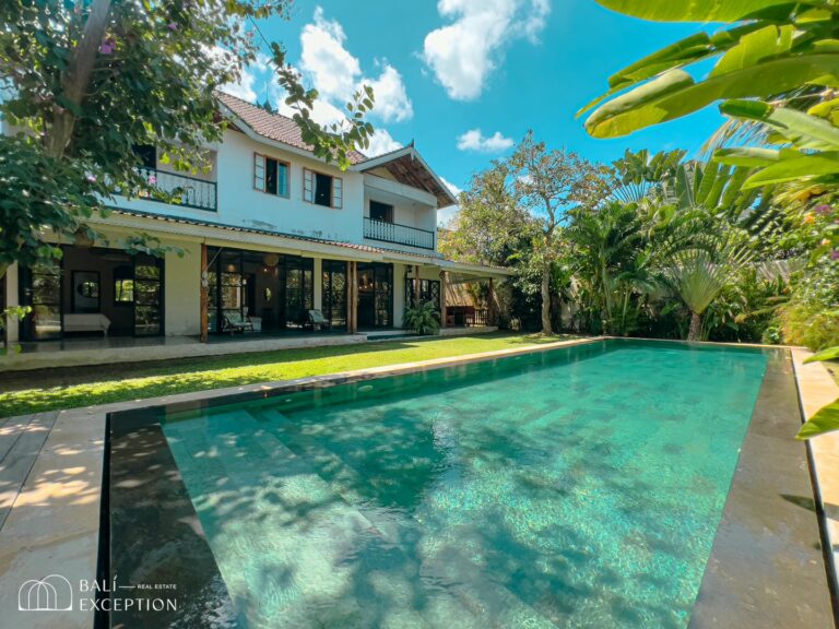 Luxury villa with pool in tropical garden setting.